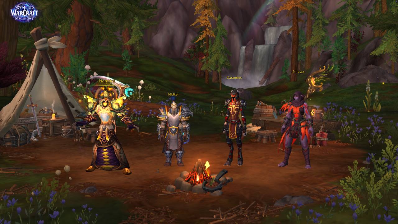 Screenshot aus World of Warcraft: Midnight. Vier Charaktere – Nemdril, Nidker, Caranthis und Niruwa – stehen um ein Lagerfeuer in einer bewaldeten Außenzone. Im Hintergrund Zelt, Fässer und ein Wasserfall.